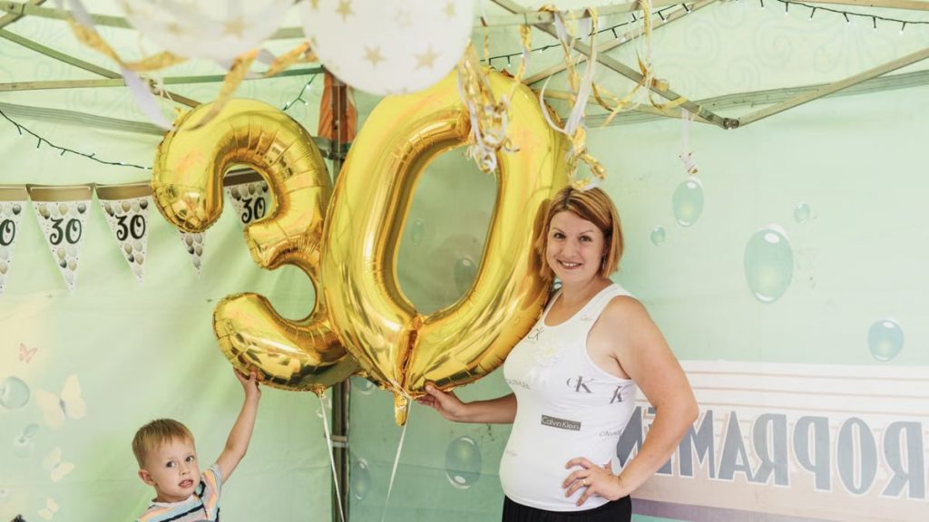 A cheerful 30th birthday party featuring gold balloons and decorations.